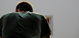 Mann steht vor einem Haus