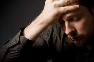 Mann fässt sich an den Kopf